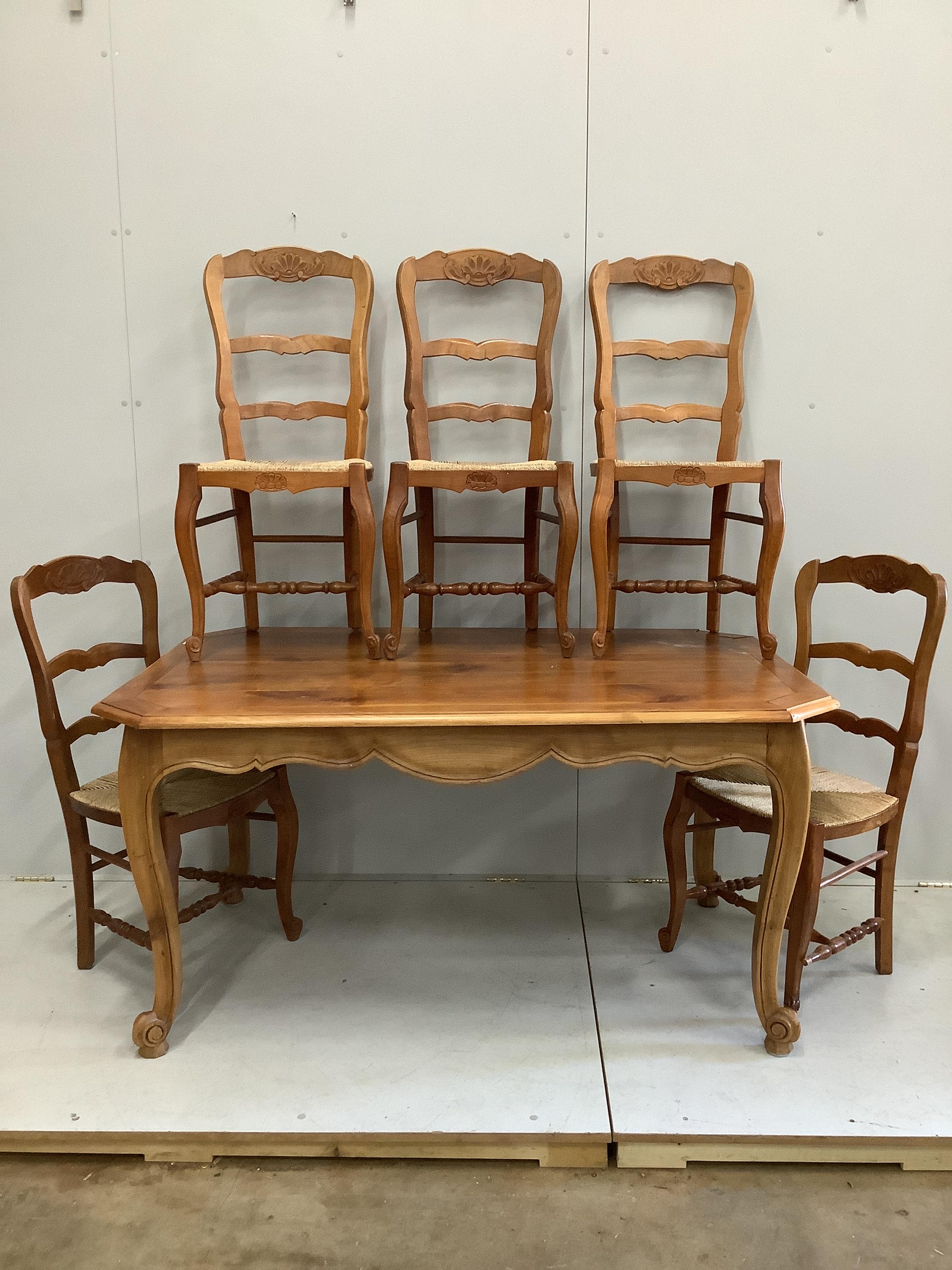A French dining table, width 150cm, depth 93cm, height 76cm and six rustic ladder back dining chairs and a stool.